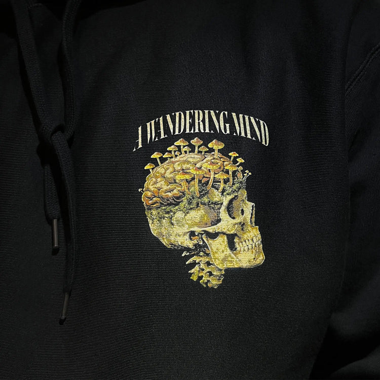 A Wandering Mind Rebirth hoodie in black front graphic detail print texture showing skull, mushrooms, moss
