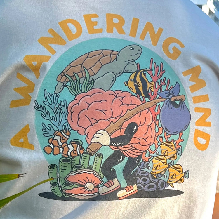 A Wandering Mind Arid Thoughts t-shirt in bone back graphic featuring wandering brain character, reef, sea life