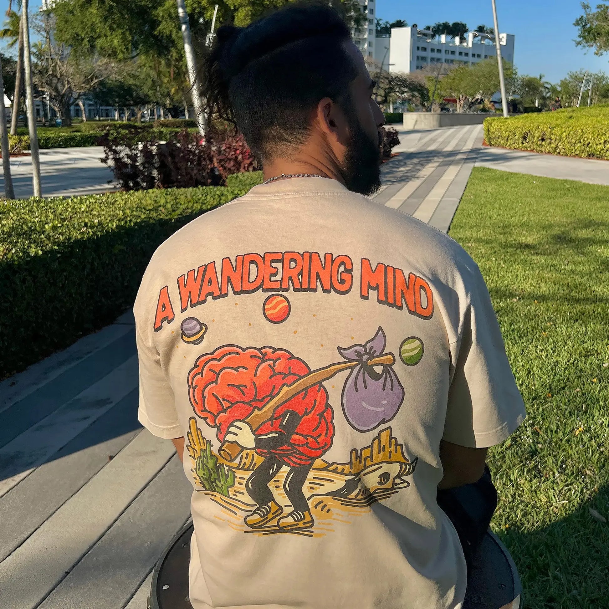A Wandering Mind Arid Thoughts t-shirt in sand back view worn on model