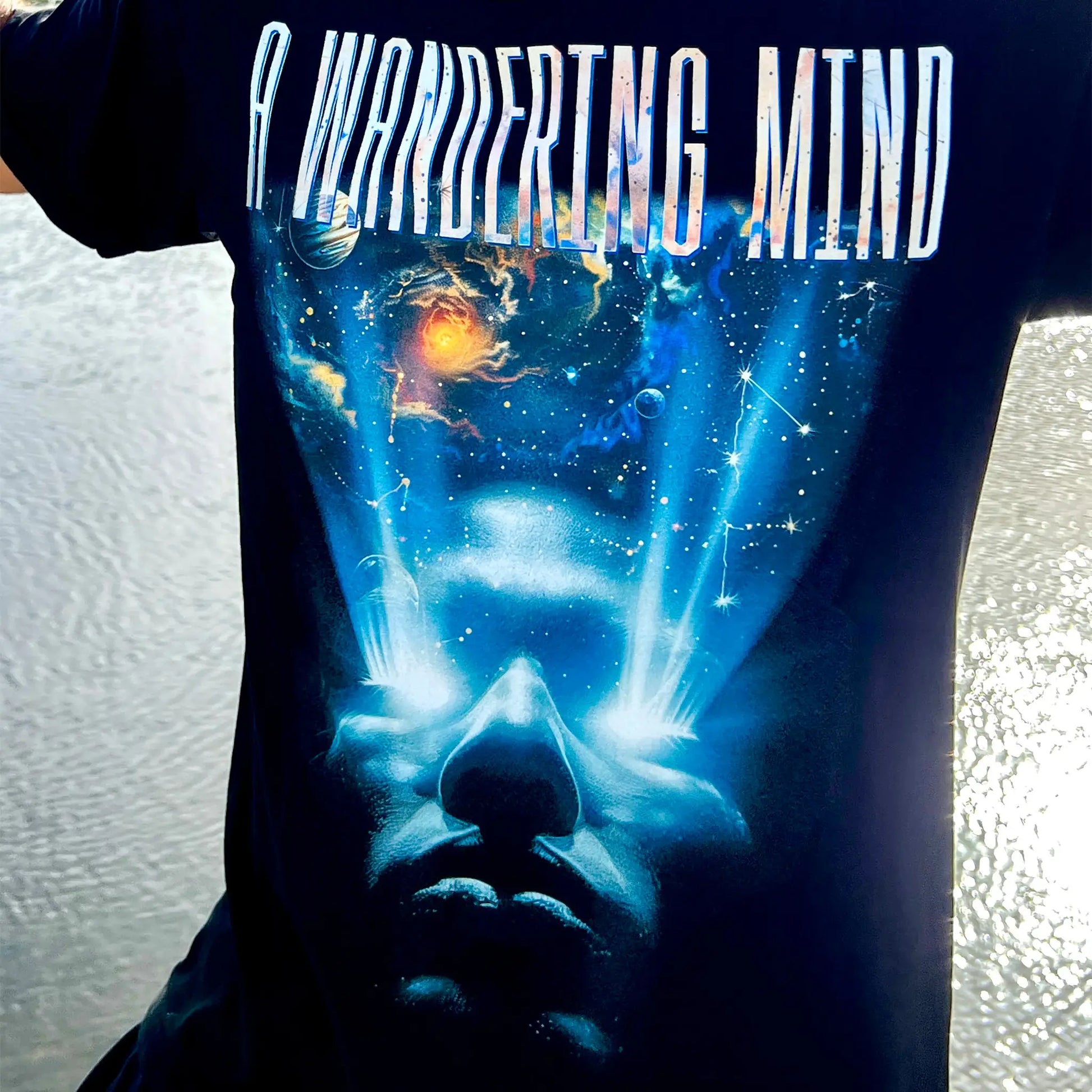 A Wandering Mind Awakening t-shirt in black front graphic featuring face, light beams, cosmic scene