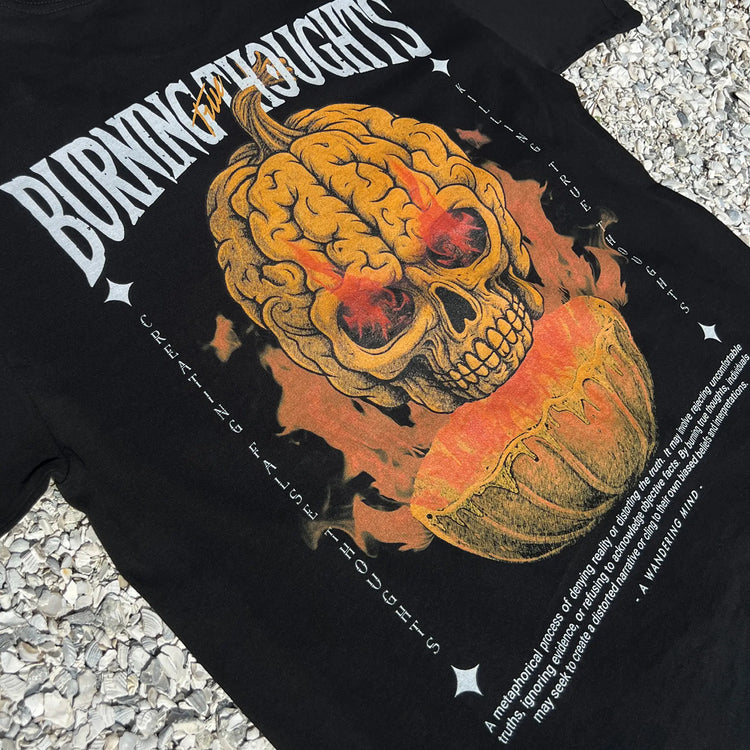 A Wandering Mind Burning Thoughts t-shirt in black back graphic angled view of skull, pumpkin, flames