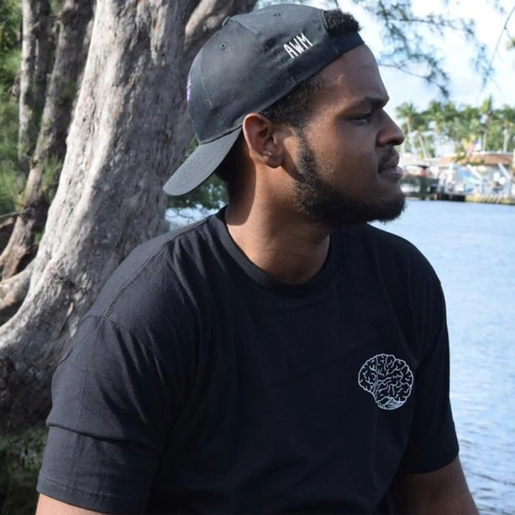 A Wandering Mind Classic Brain White Logo t-shirt in black side view worn on model