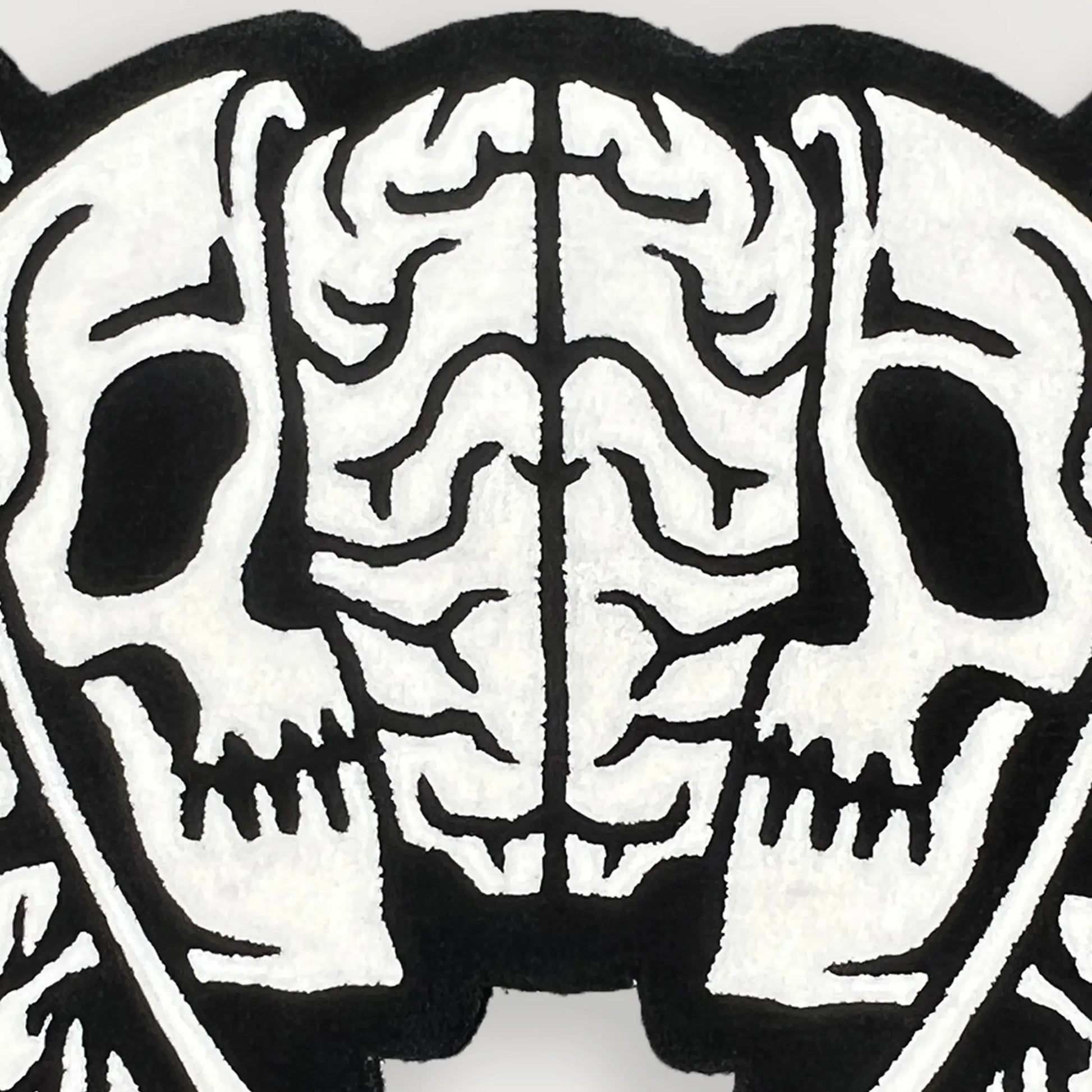 A Wandering Mind Divided Self rug in black and white detail showing face, skull, brain