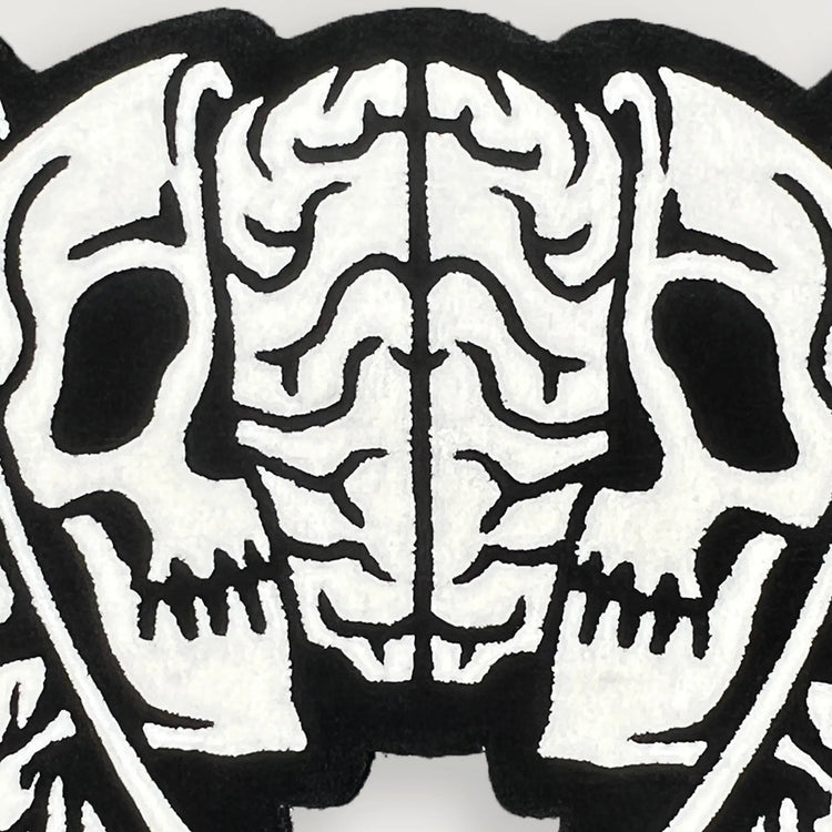 A Wandering Mind Divided Self rug in black and white detail showing face, skull, brain
