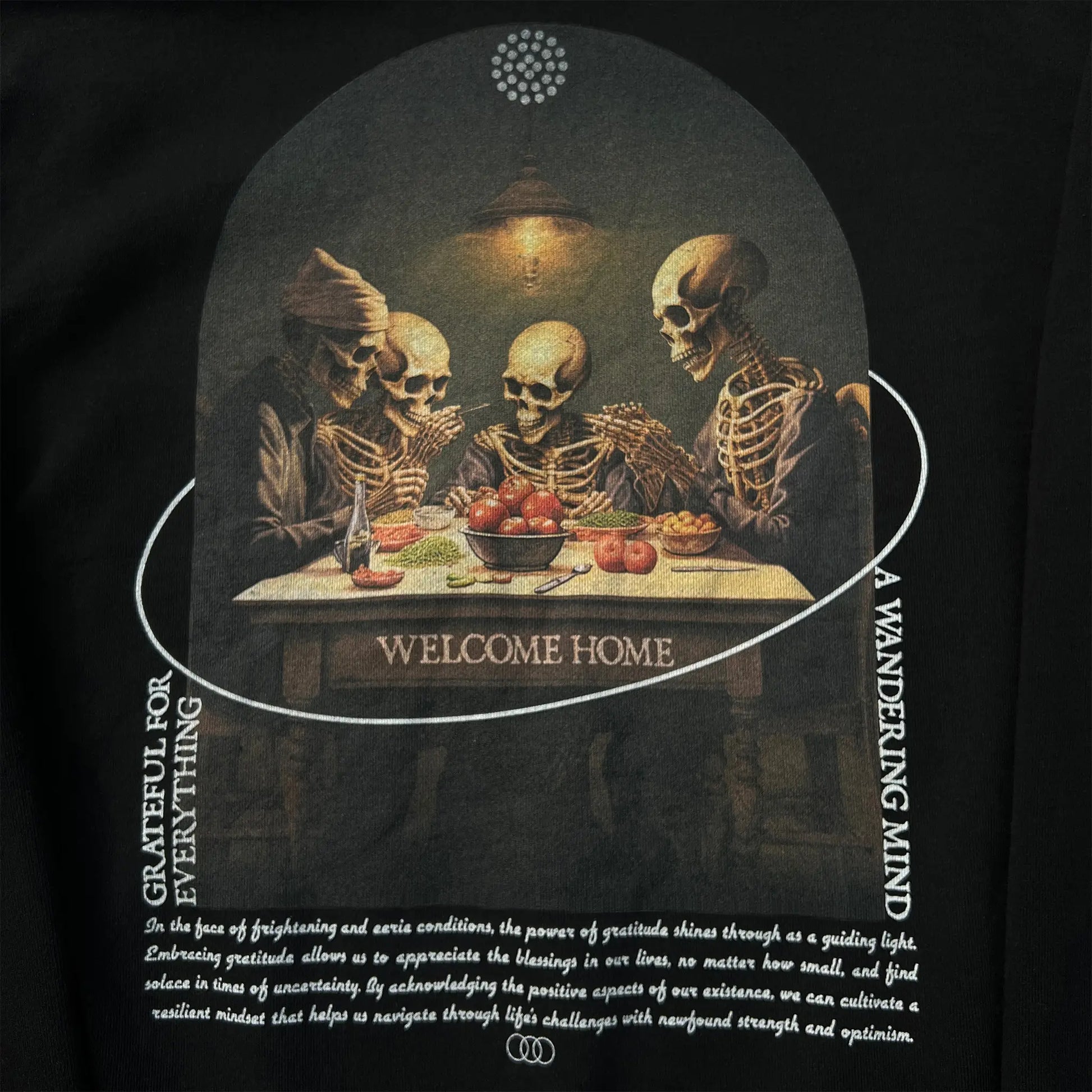 A Wandering Mind Grateful for Everything hoodie in black back graphic detail print texture showing skeletons at table, food, interior scene