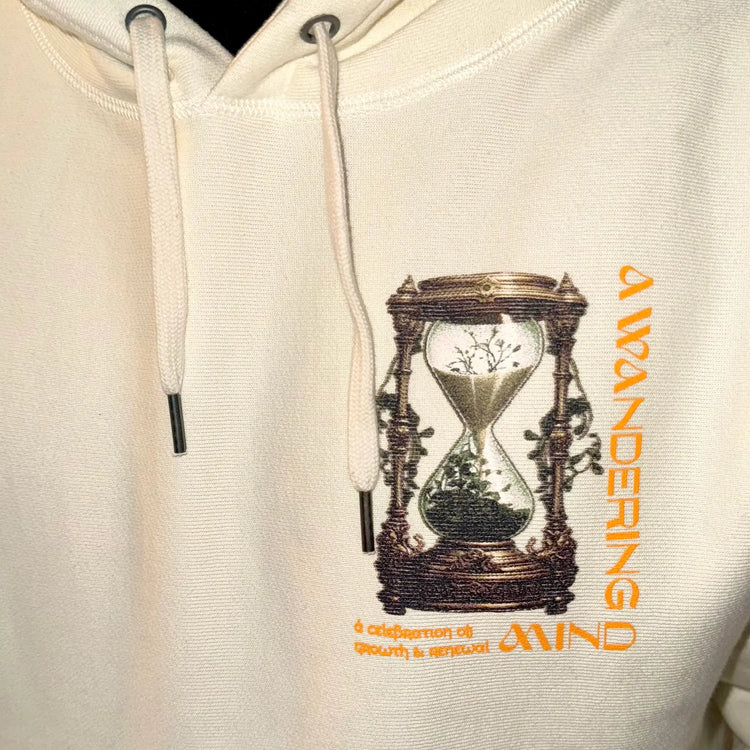 A Wandering Mind Growth and Renewal hoodie in bone front graphic detail print texture showing hourglass, foliage, symbolic elements