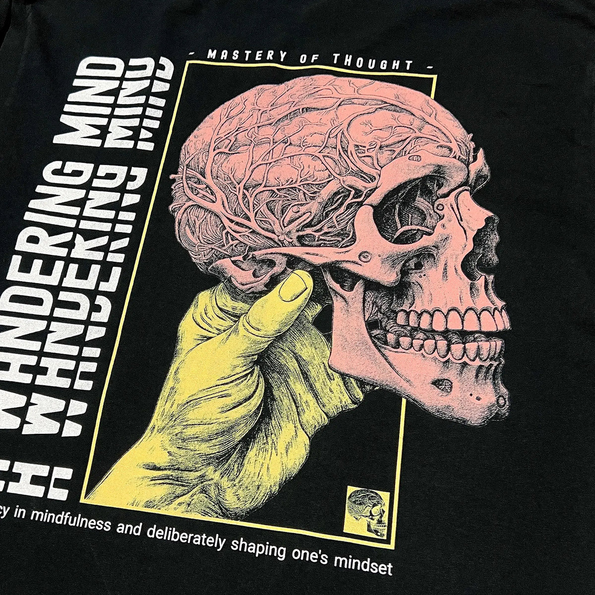 A Wandering Mind Mastery of Thought long sleeve t-shirt in black back graphic featuring hand holding skull, exposed brain