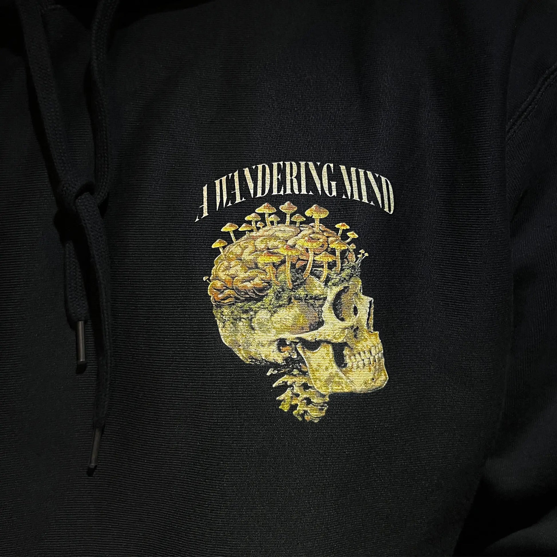 A Wandering Mind Rebirth hoodie in black front graphic detail print texture showing skull, mushrooms, moss