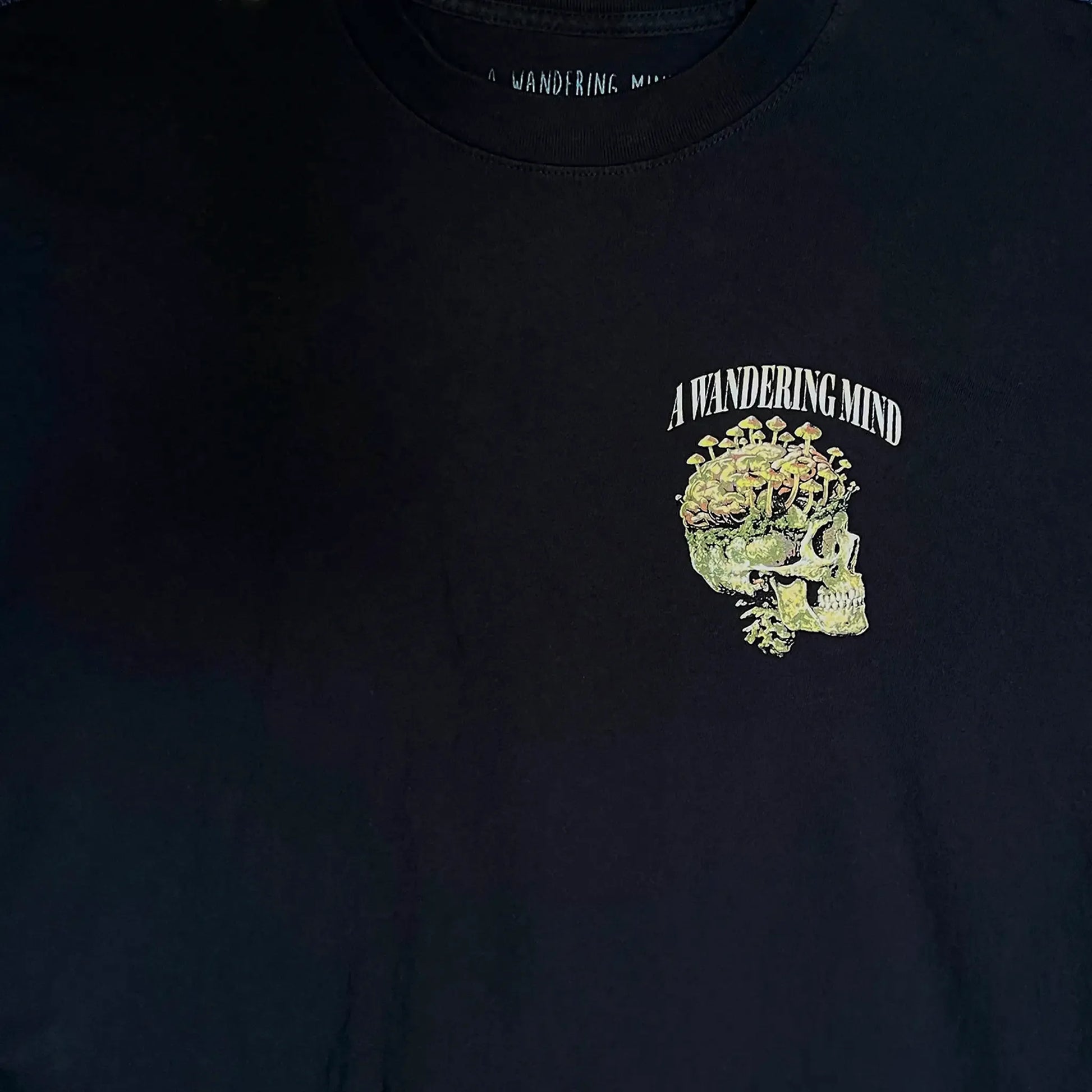 A Wandering Mind Rebirth t-shirt in black front graphic detail showing skull, mushrooms, moss