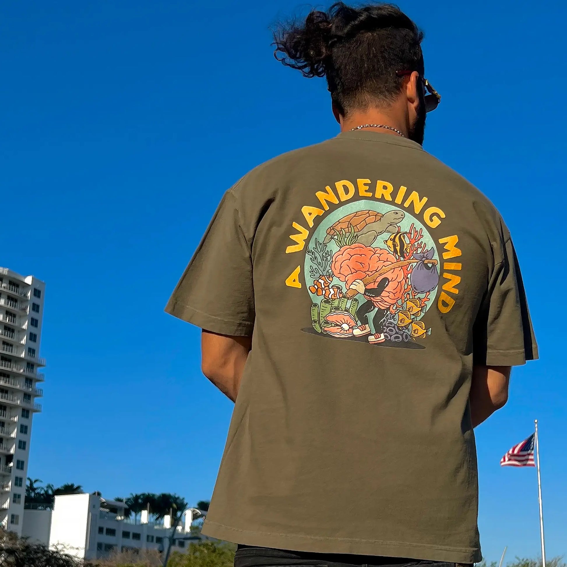A Wandering Mind Sunken Thoughts t-shirt in olive back view worn on model