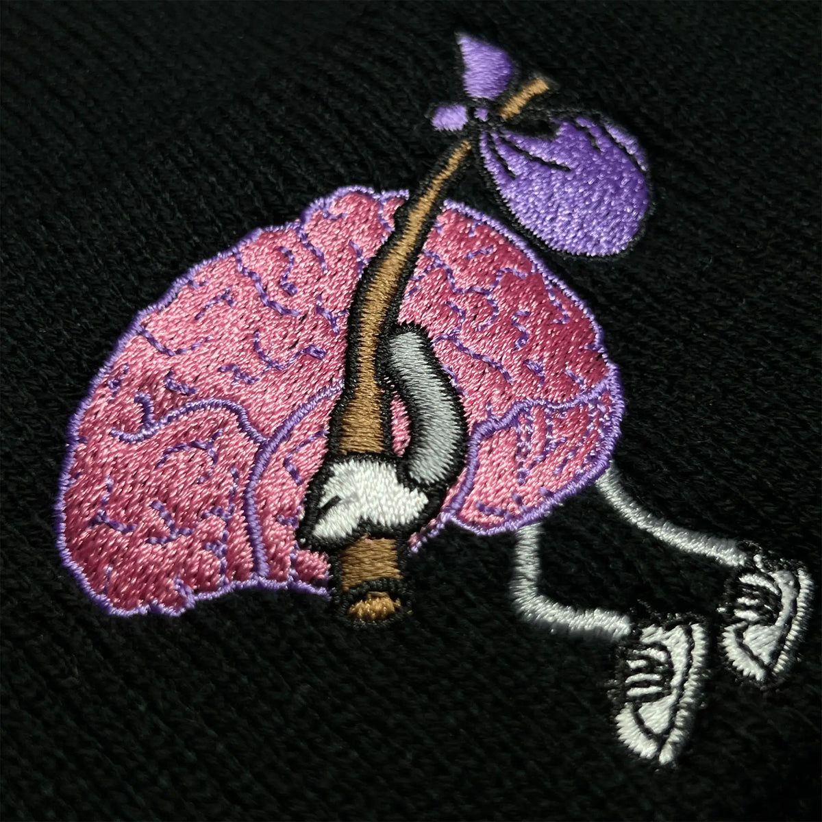 A Wandering Mind Wandering beanie in black embroidered logo detail showing wandering brain character